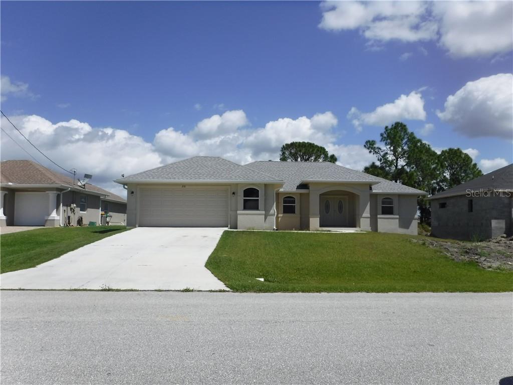216 Marker Road Rotonda West, FL 33947 - Photo 1 of 1 a front view of a house with a yard and garage