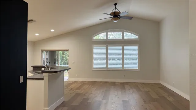 an empty room with a kitchen and windows