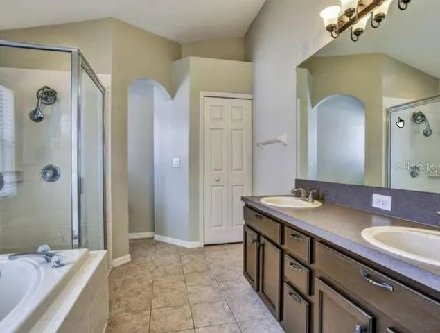 a spacious bathroom with a granite countertop sink a mirror and a shower