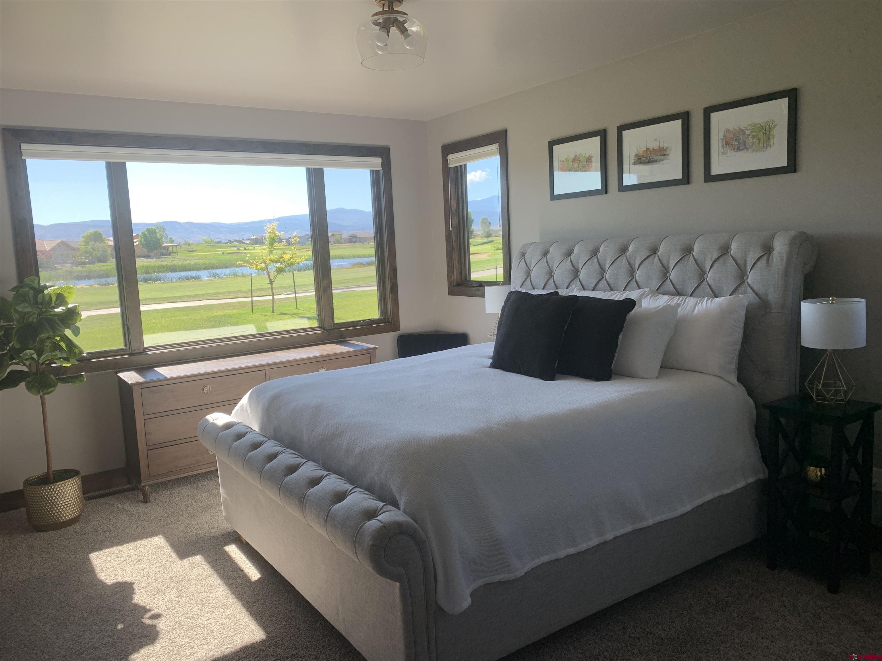 2533 Bear Lake Drive Montrose, CO 81401 - Photo 16 of 34 a bedroom with a large bed and a large window