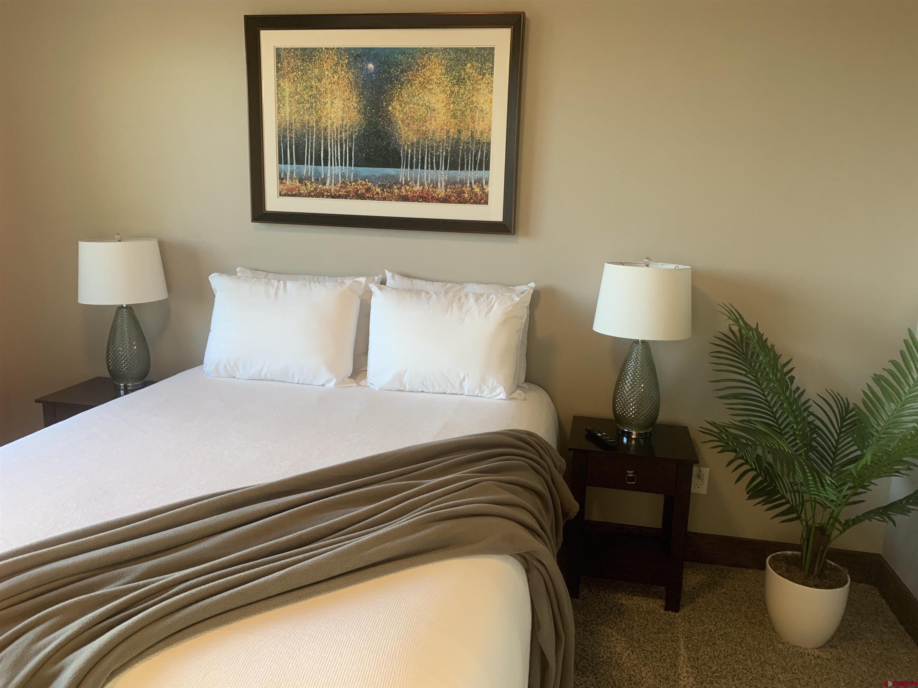 2533 Bear Lake Drive Montrose, CO 81401 - Photo 29 of 34 a bedroom with a bed and a lamp on table