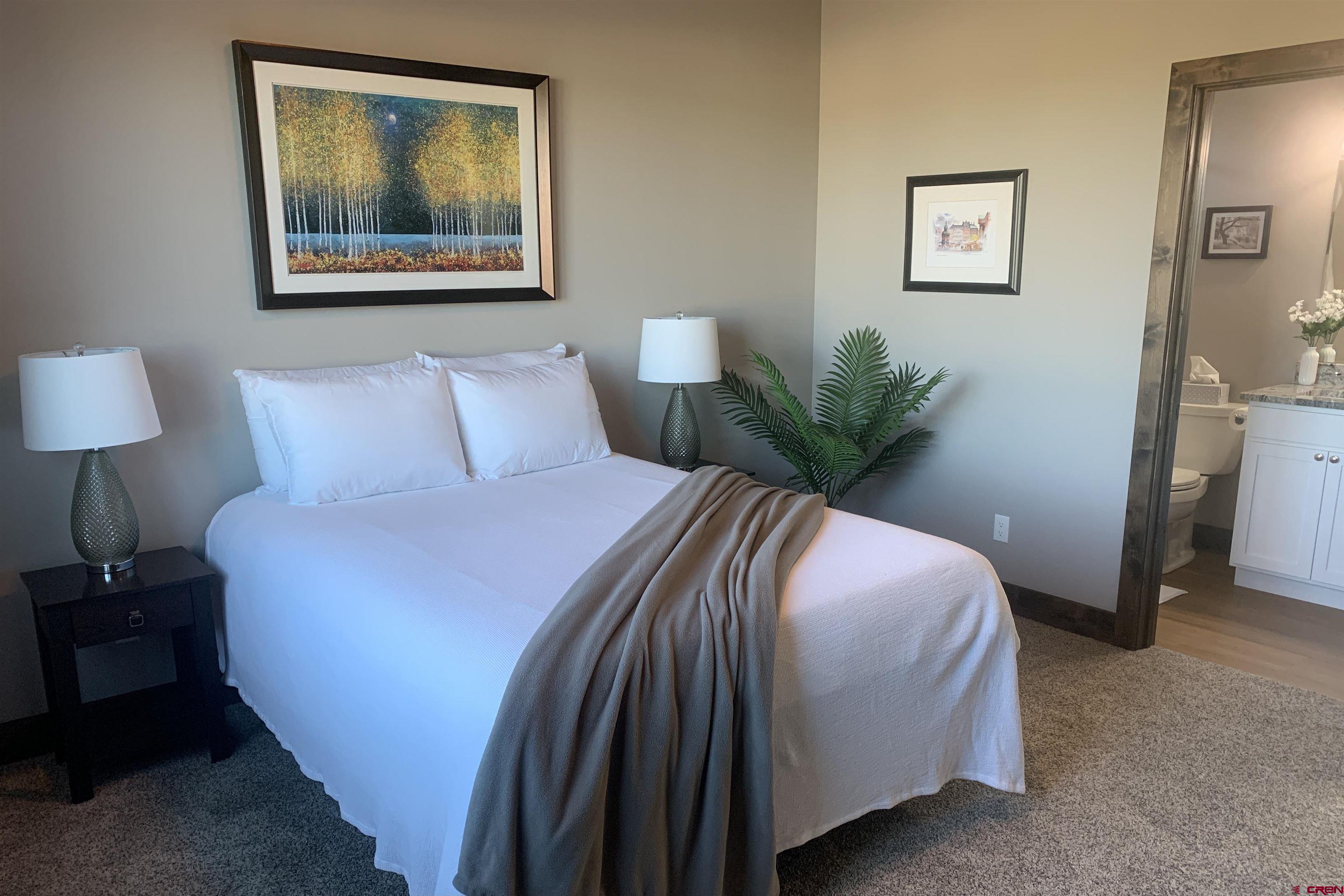 2533 Bear Lake Drive Montrose, CO 81401 - Photo 31 of 34 a bedroom with a bed and a painting on the wall