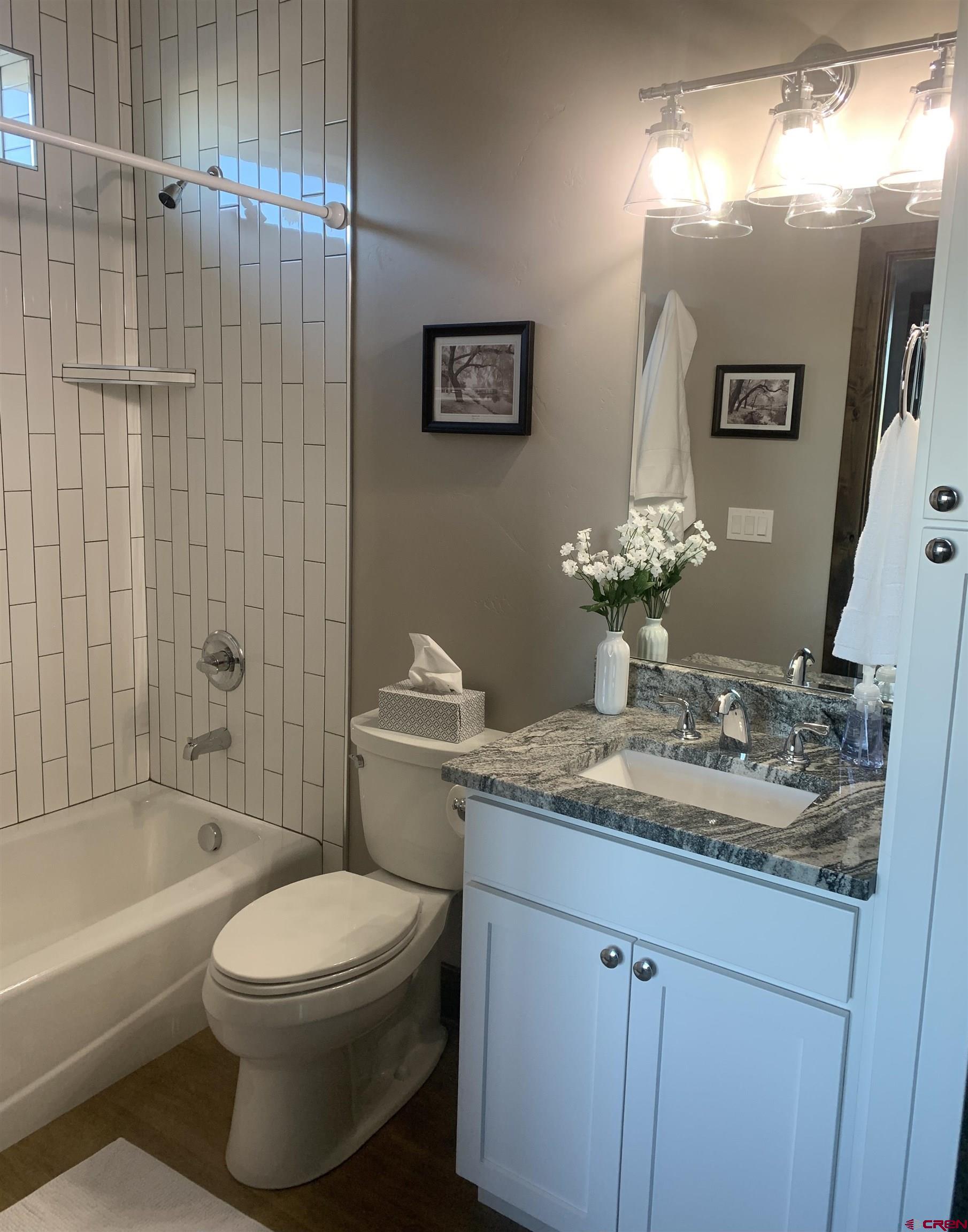 2533 Bear Lake Drive Montrose, CO 81401 - Photo 32 of 34 a bathroom with a granite countertop sink a toilet a mirror and bathtub