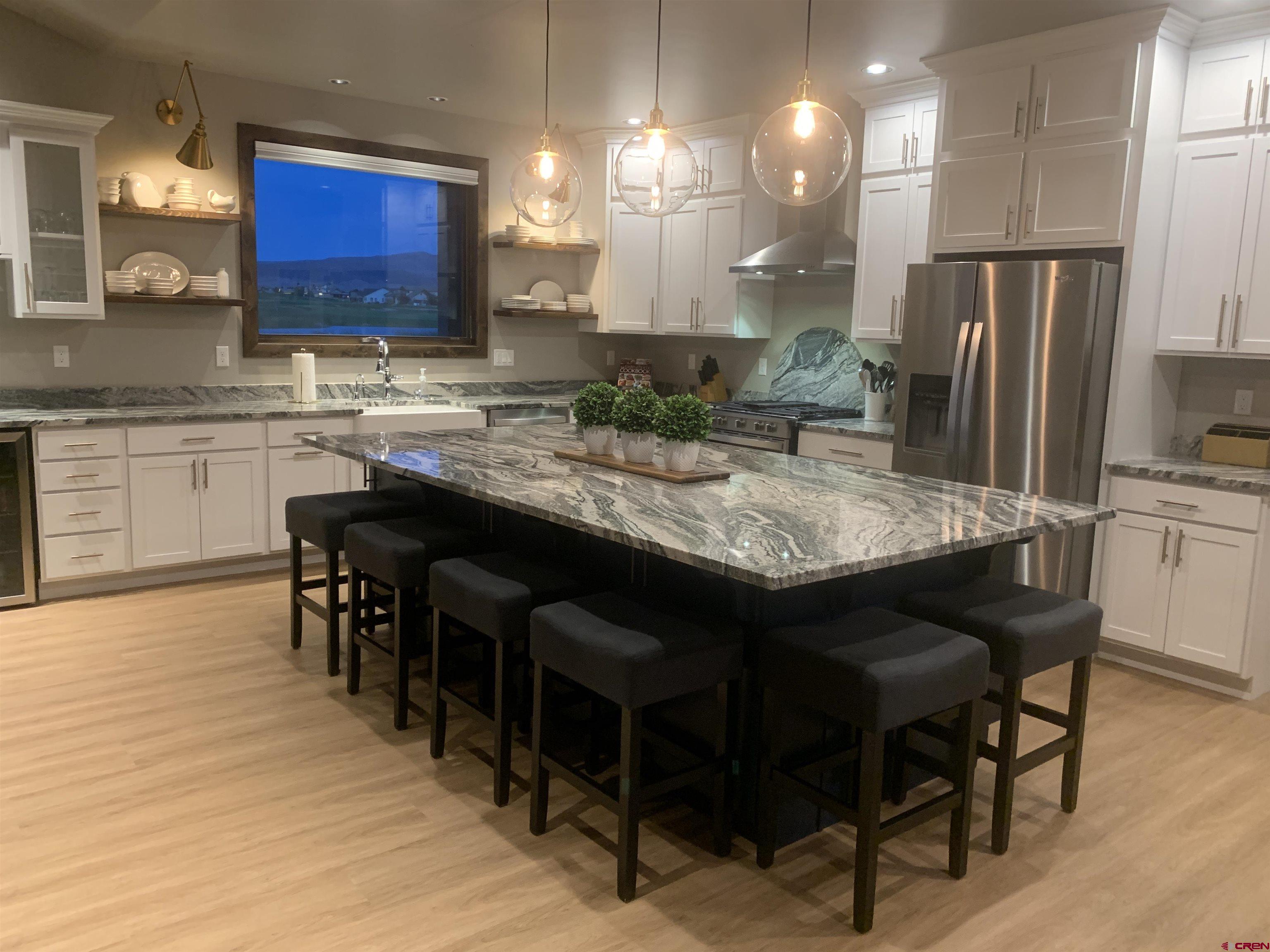2533 Bear Lake Drive Montrose, CO 81401 - Photo 4 of 34 a kitchen with stainless steel appliances granite countertop a table chairs sink refrigerator and cabinets