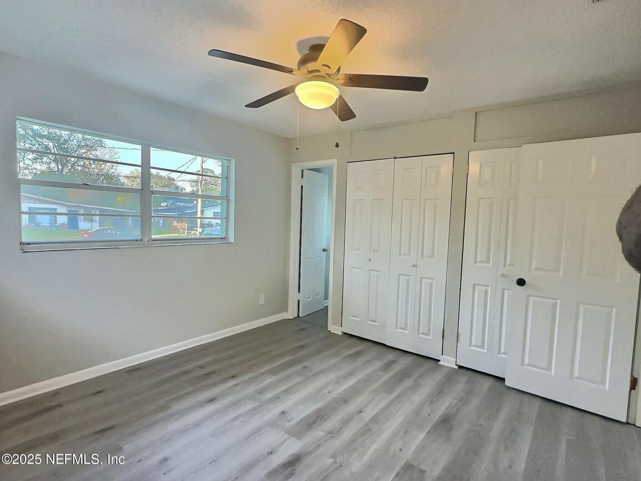 7456 Centauri Road Jacksonville, FL 32210 - Photo 13 of 26 a view of an empty room with wooden floor and a window