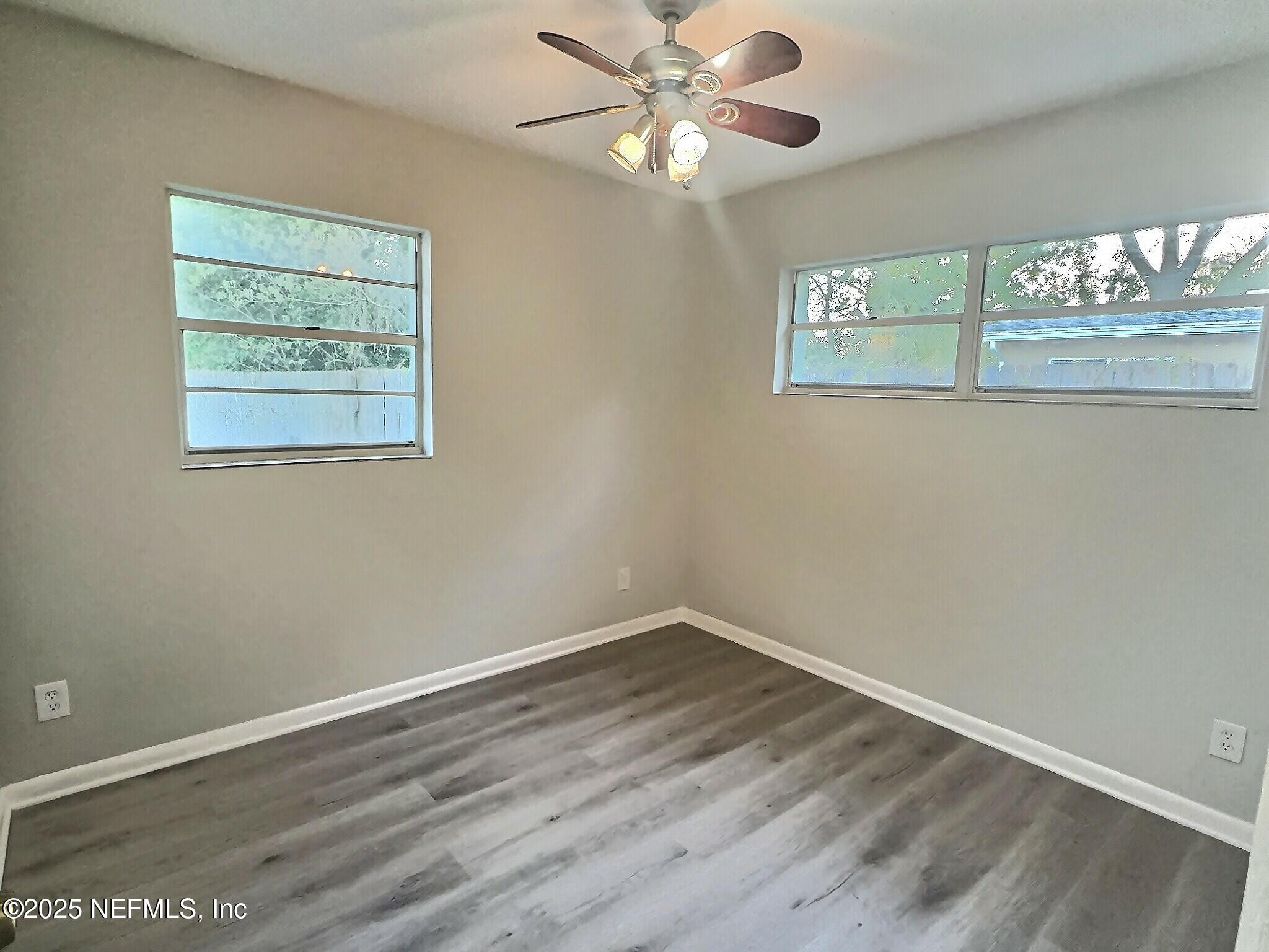 7456 Centauri Road Jacksonville, FL 32210 - Photo 18 of 26 a view of an empty room with wooden floor and a window