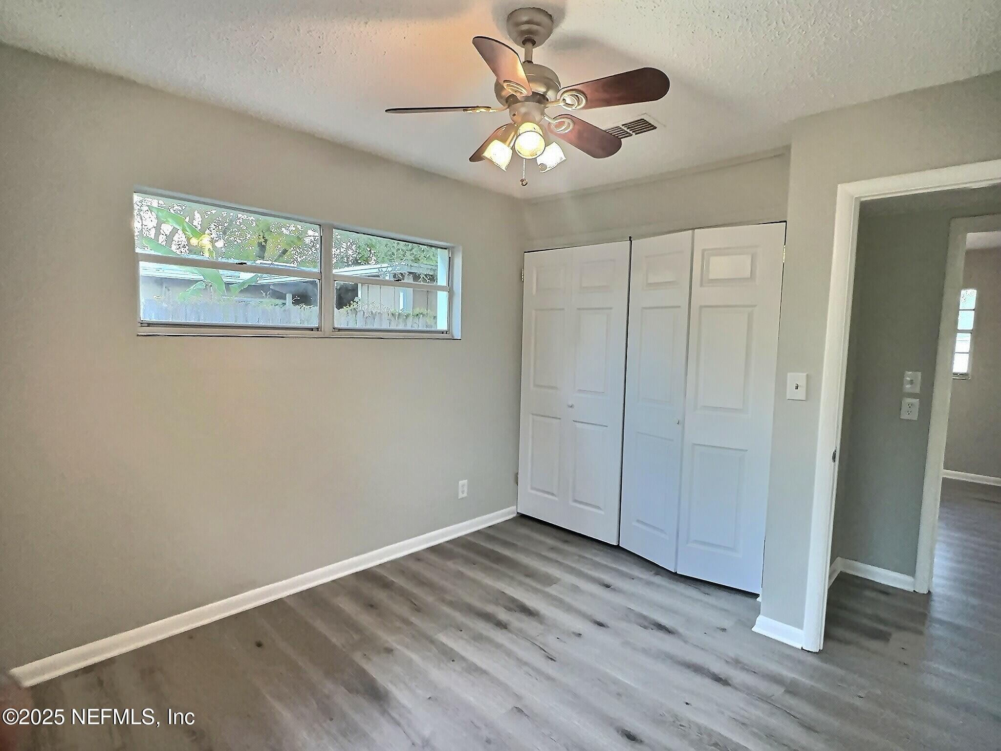7456 Centauri Road Jacksonville, FL 32210 - Photo 19 of 26 a view of an empty room with wooden floor