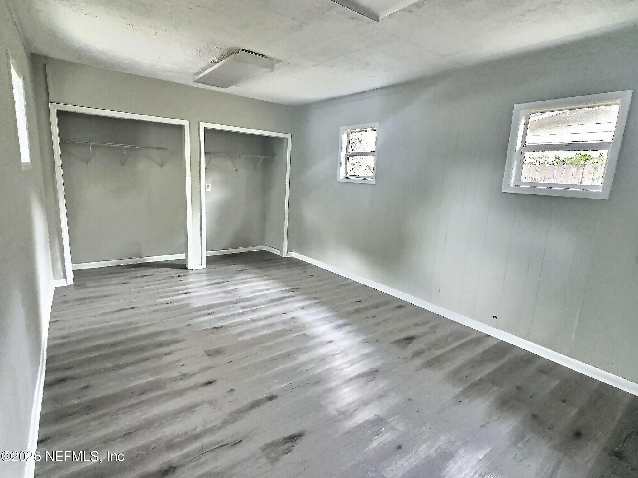 7456 Centauri Road Jacksonville, FL 32210 - Photo 20 of 26 a view of an empty room with wooden floor and a window
