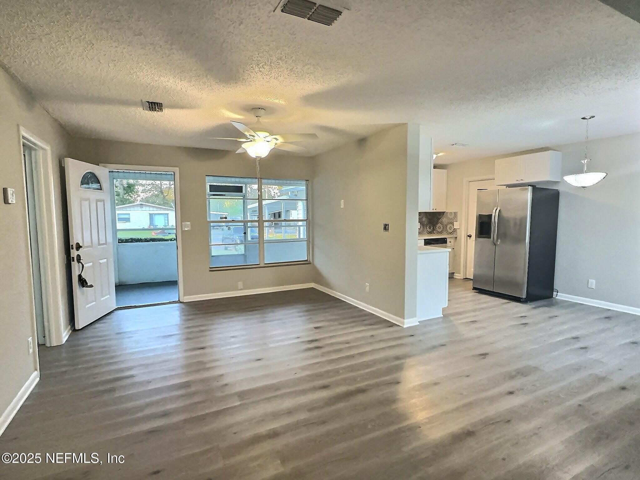 7456 Centauri Road Jacksonville, FL 32210 - Photo 5 of 26 an empty room with wooden floor and windows
