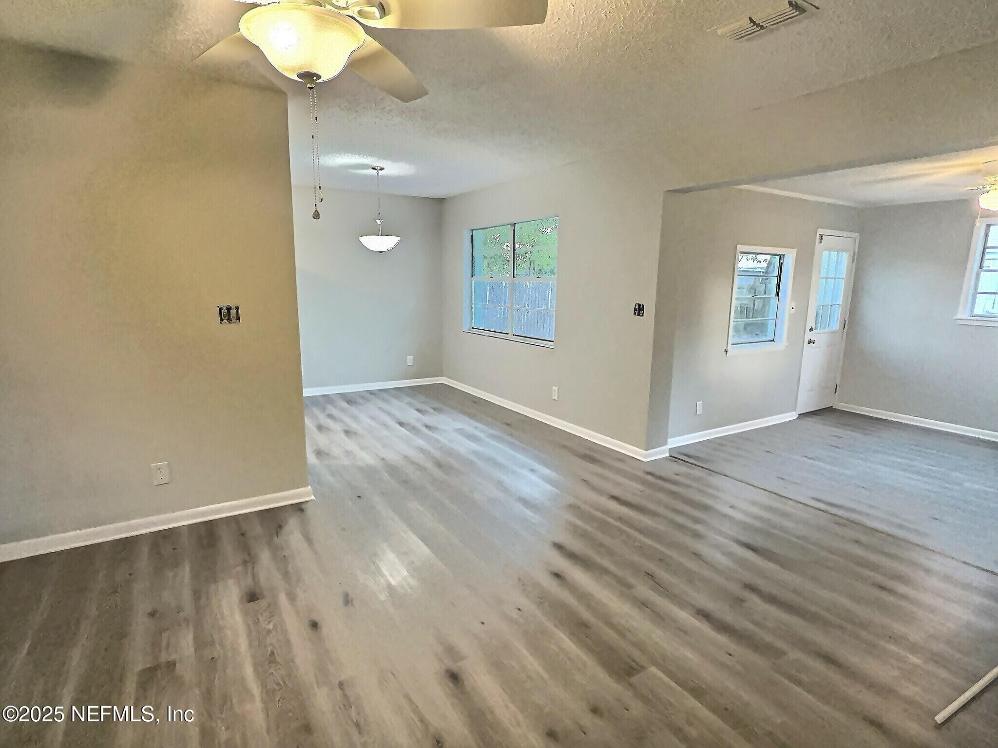 7456 Centauri Road Jacksonville, FL 32210 - Photo 6 of 26 an empty room with wooden floor and windows