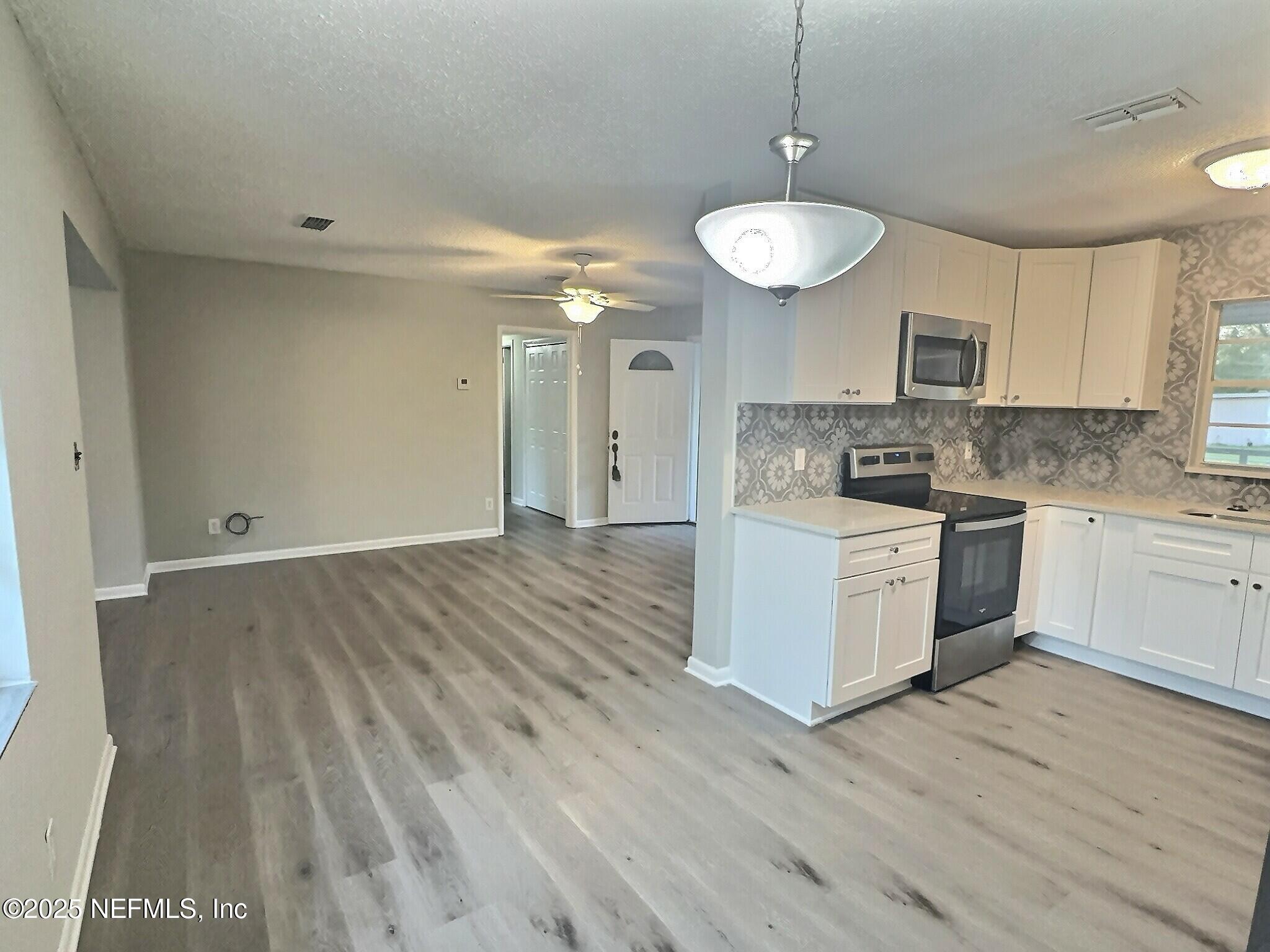 7456 Centauri Road Jacksonville, FL 32210 - Photo 7 of 26 a kitchen with a sink cabinets and wooden floor