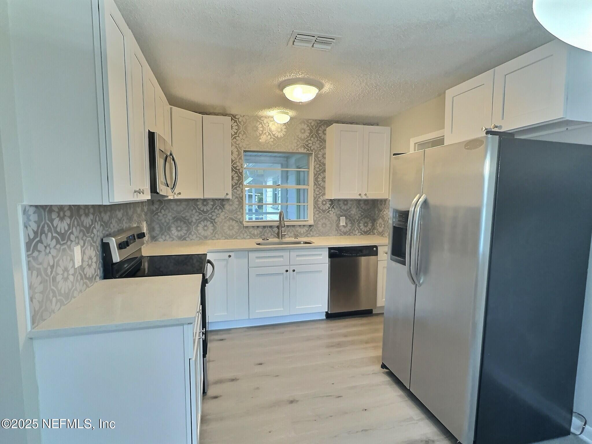 7456 Centauri Road Jacksonville, FL 32210 - Photo 8 of 26 a kitchen with stainless steel appliances granite countertop a refrigerator sink and stove