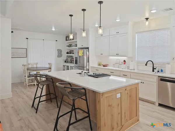 a kitchen with kitchen island a sink table and chairs