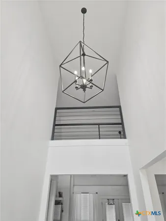 a living room with furniture a flat screen tv and a chandelier