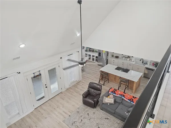 a dining room with wooden floor a chandelier a wooden table and chairs