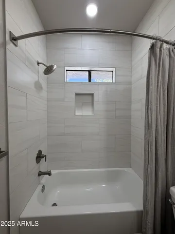a bathroom with a shower and a bath tub