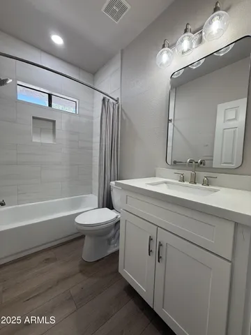 a bathroom with a toilet a sink a mirror and a bathtub