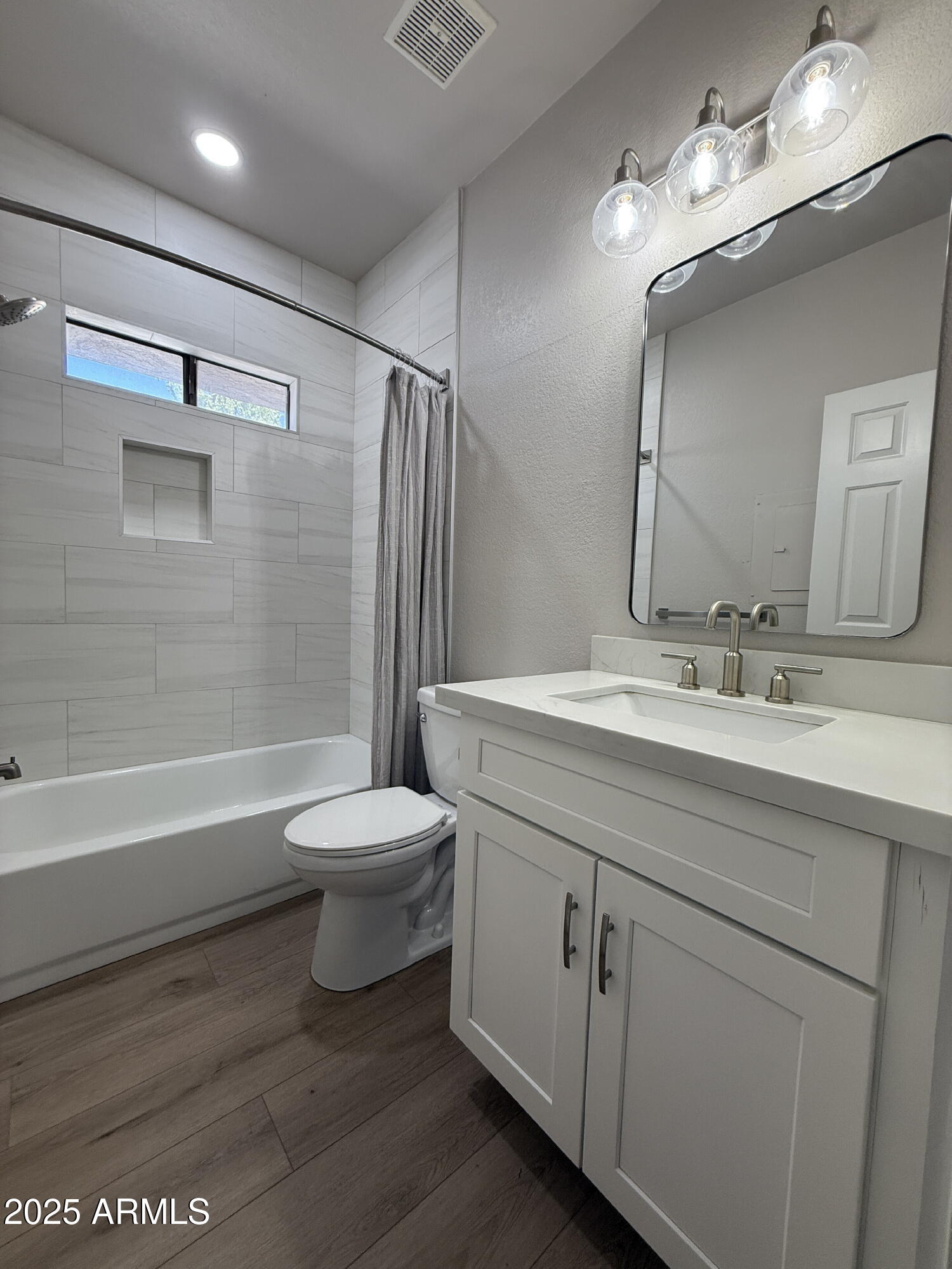 1287 North Alma School Road, Unit 207 Chandler, AZ 85224 - Photo 7 of 9 a bathroom with a toilet a sink a mirror and a bathtub