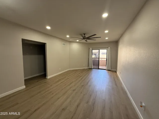 a view of empty room with window and wooden floor