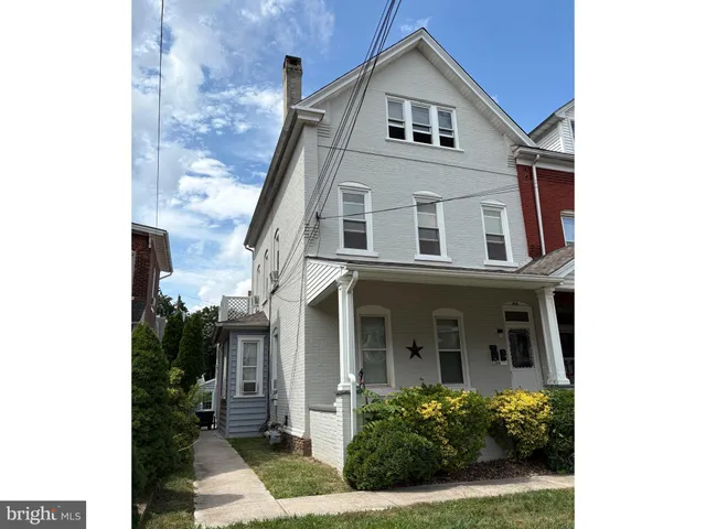 a front view of a house with plants