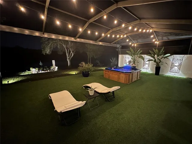 a living room with furniture a flat screen tv and a floor to ceiling window