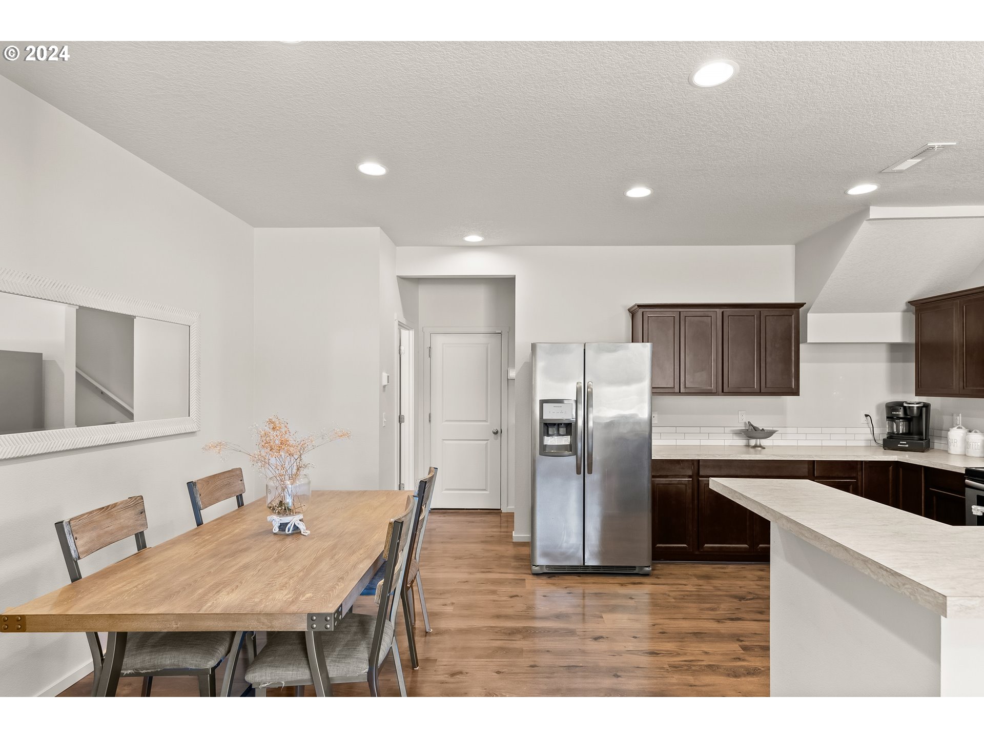 2183 Southeast 19th Street Gresham, OR 97080 - Photo 14 of 26 a kitchen with stainless steel appliances kitchen island granite countertop a refrigerator a sink a stove a dining table and chairs