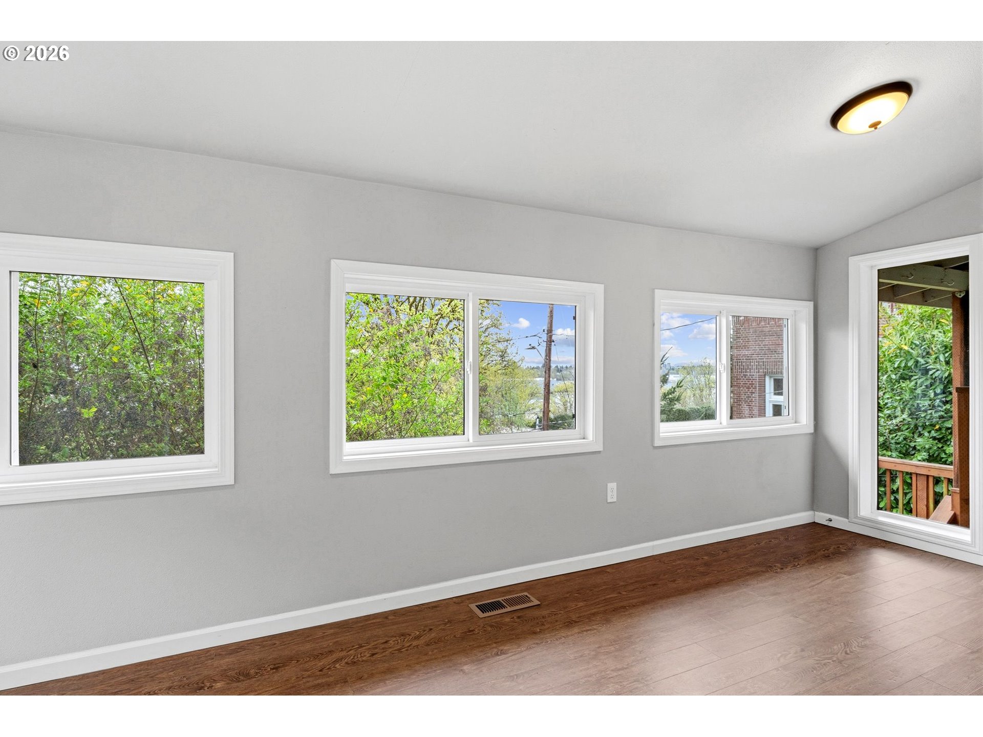 10505 Northwest 2nd Street Portland, OR 97231 - Photo 18 of 39 a view of an empty room with wooden floor and windows