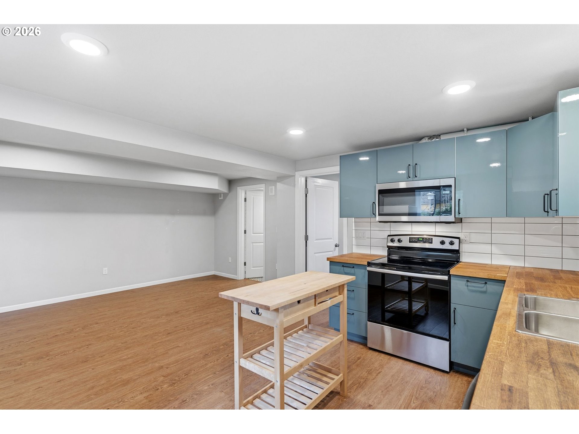 10505 Northwest 2nd Street Portland, OR 97231 - Photo 25 of 39 a kitchen with stainless steel appliances kitchen island granite countertop a stove a sink and a microwave