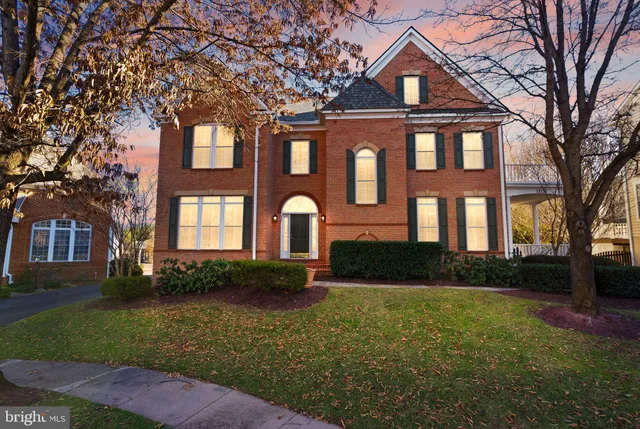 a front view of a building with a yard and trees