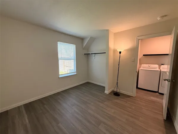 an empty room with wooden floor and a window