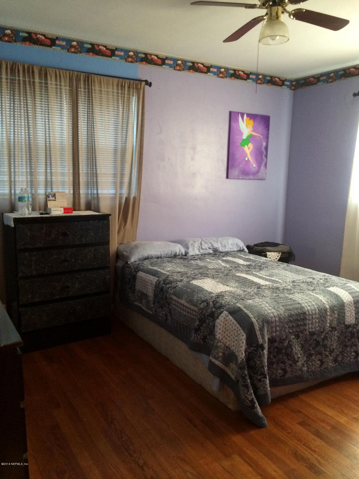 2433 Sam Road Jacksonville, FL 32216 - Photo 16 of 22 a bedroom with a bed and a chandelier