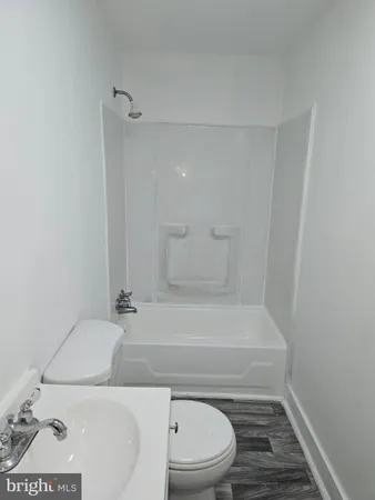 a bathroom with a sink a toilet and bathtub