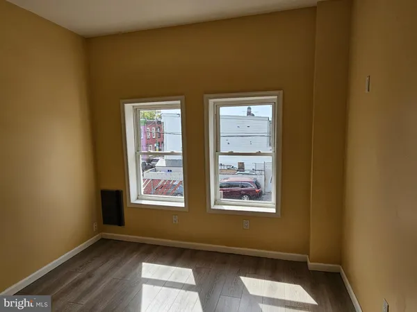 a view of an empty room with wooden floor