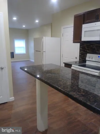 a kitchen with kitchen island granite countertop a sink and a stove