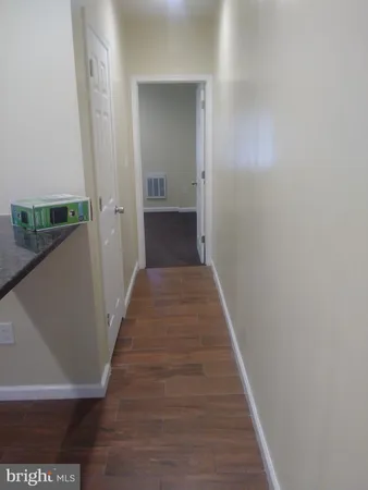a view of a hallway with wooden floor and staircase