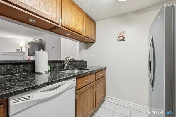 a kitchen with stainless steel appliances granite countertop a sink a stove and a refrigerator