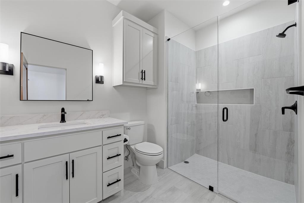 2004 Denali Pass Aledo, TX 76008 - Photo 40 of 40 a bathroom with a granite countertop sink a toilet and a mirror