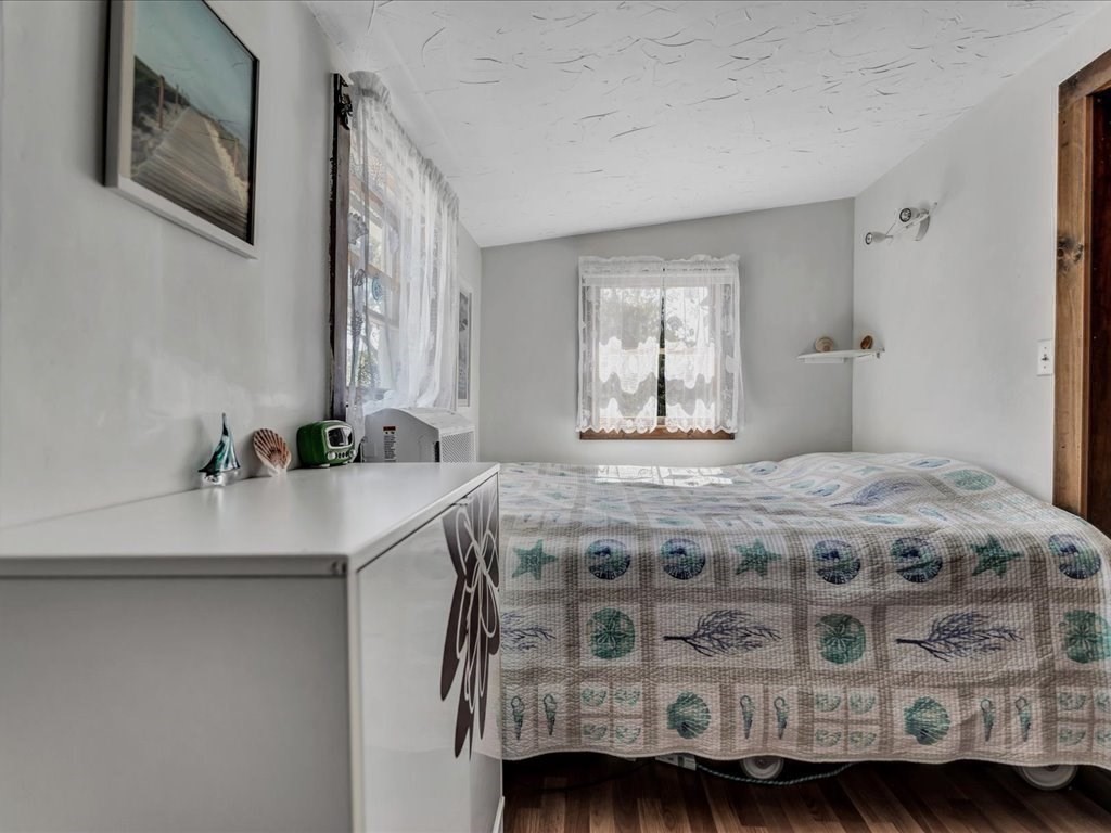 56 Ryder Street Wareham, MA 02532 - Photo 12 of 29 a bedroom with a bed a mirror on the dresser and a chandelier