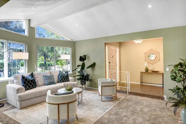 a living room with furniture a window and a potted plant