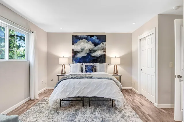 a bedroom with a bed and a painting on the wall