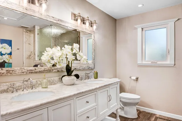 a bathroom with a granite countertop sink and a toilet