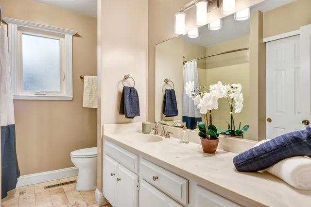 a bathroom with a granite countertop sink a toilet and a mirror