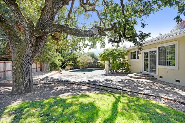 a view of a house with backyard and a tree