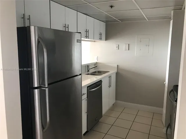 a metallic refrigerator freezer sitting in a kitchen