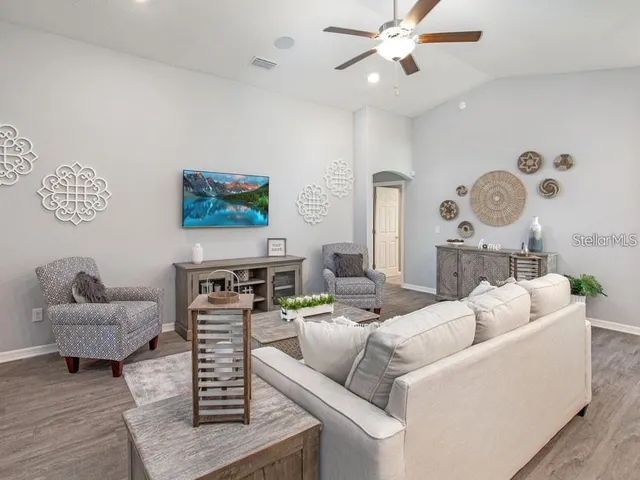 a living room with furniture and a view of kitchen
