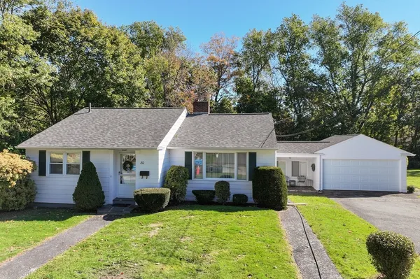 a front view of a house with a yard and trees