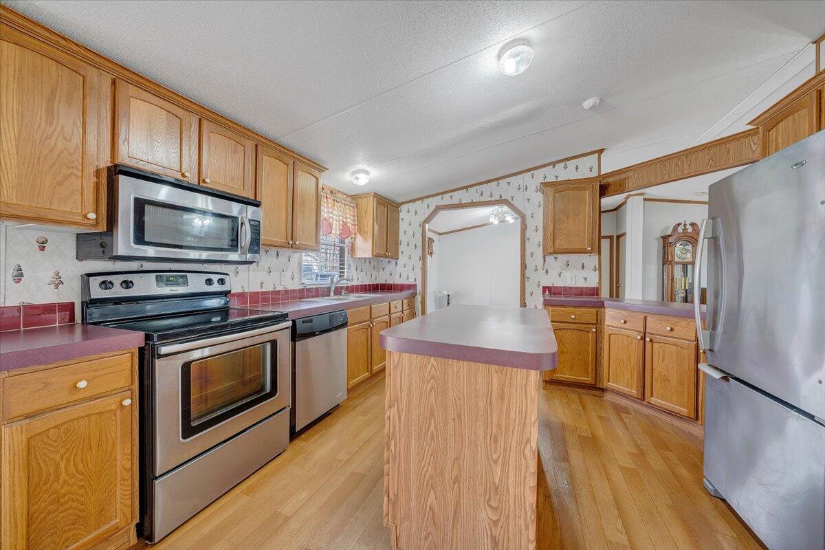 829 Moorman Mill Road Rustburg, VA 24588 - Photo 19 of 45 a kitchen with stainless steel appliances granite countertop a refrigerator a stove top oven a sink and dishwasher with wooden floor