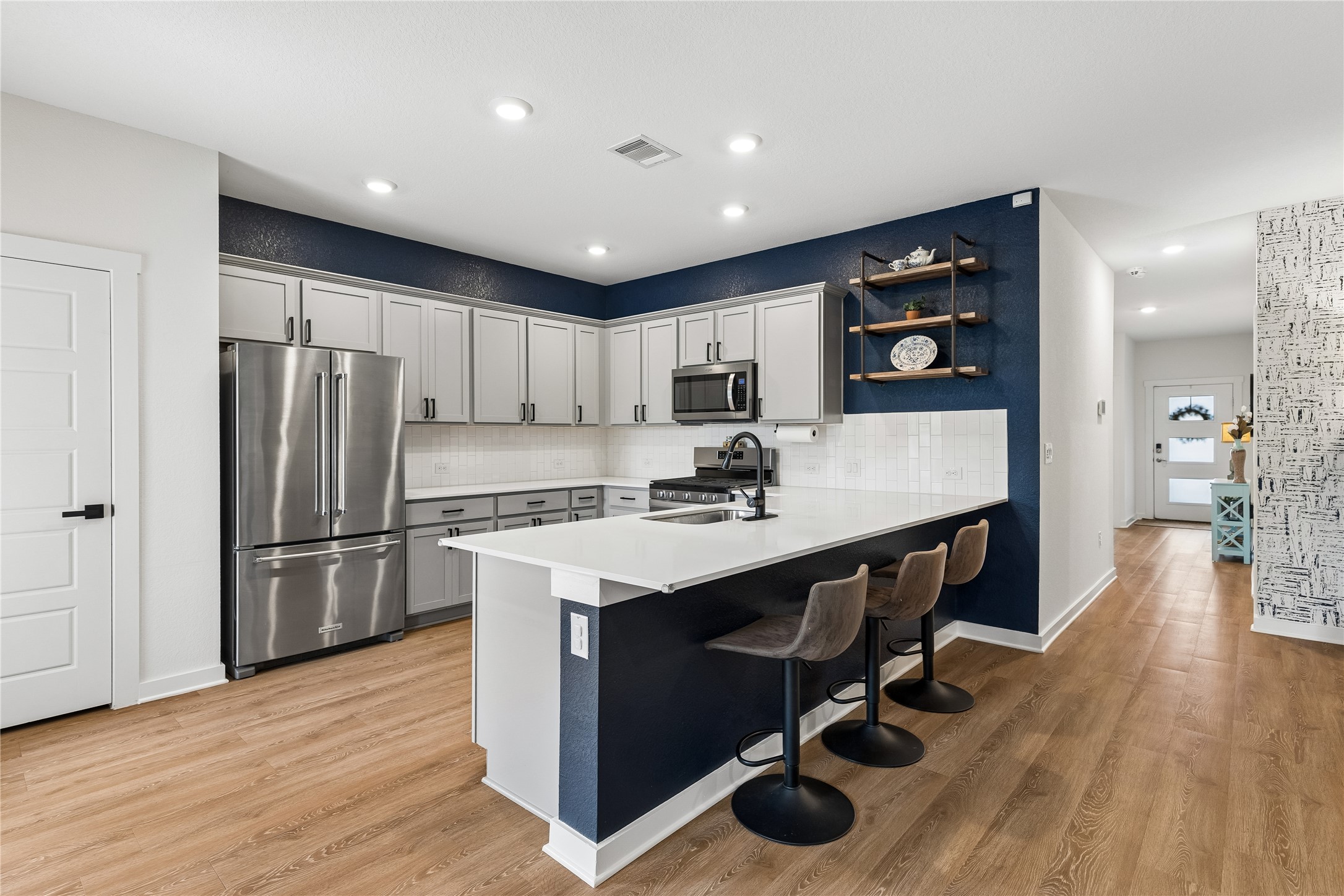 249 Century Plant Road Leander, TX 78641 - Photo 3 of 22 a kitchen with stainless steel appliances granite countertop a refrigerator a sink dishwasher a stove and a microwave oven on table with wooden floor