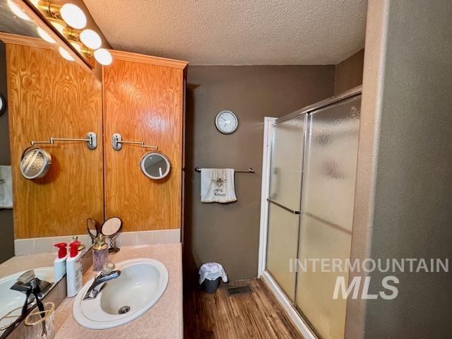 7880 Sweet Ola Highway Sweet, ID 83670 - Photo 12 of 24 Bathroom with a textured ceiling, a shower stall, vanity, and dark wood-type flooring