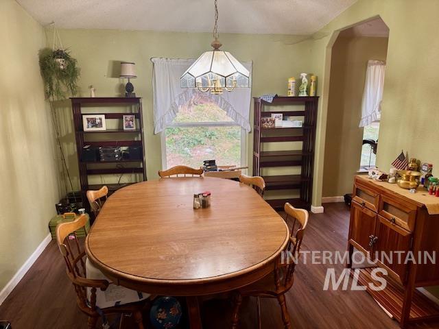 7880 Sweet Ola Highway Sweet, ID 83670 - Photo 4 of 24 Dining room with dark wood-type flooring, arched walkways, and a chandelier